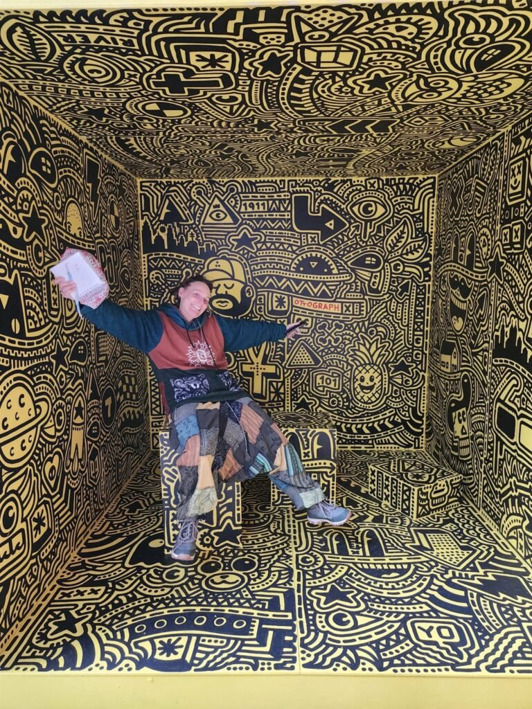 Kelly holding her sketchbook in a doodle art room at the STRAAT Museum, Amsterdam
