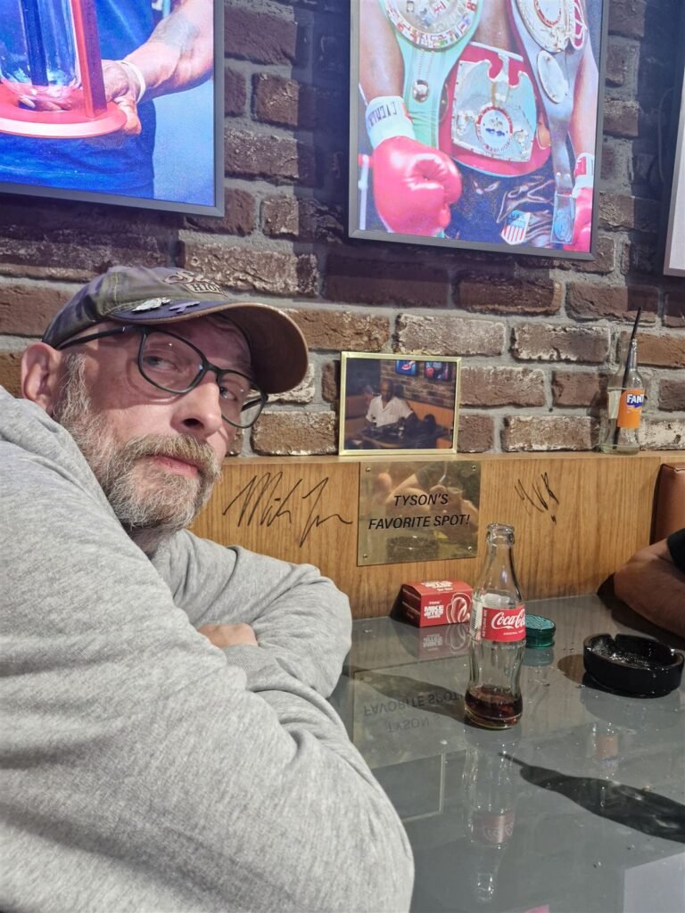 Paul sitting in Mike Tyson's favourite seat at Tyson 2.0 coffeeshop, Amsterdam